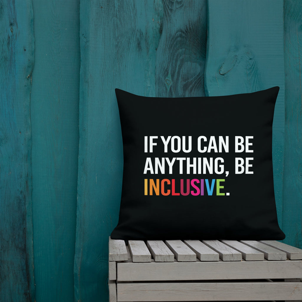This is an image of a black premium Be Inclusive throw cushion. In the middle of the square throw cushion, the following phrase is printed in white upper case letters, "IF YOU CAN BE ANYTHING, BE INCLUSIVE." The word INCLUSIVE is in rainbow-like colors. 