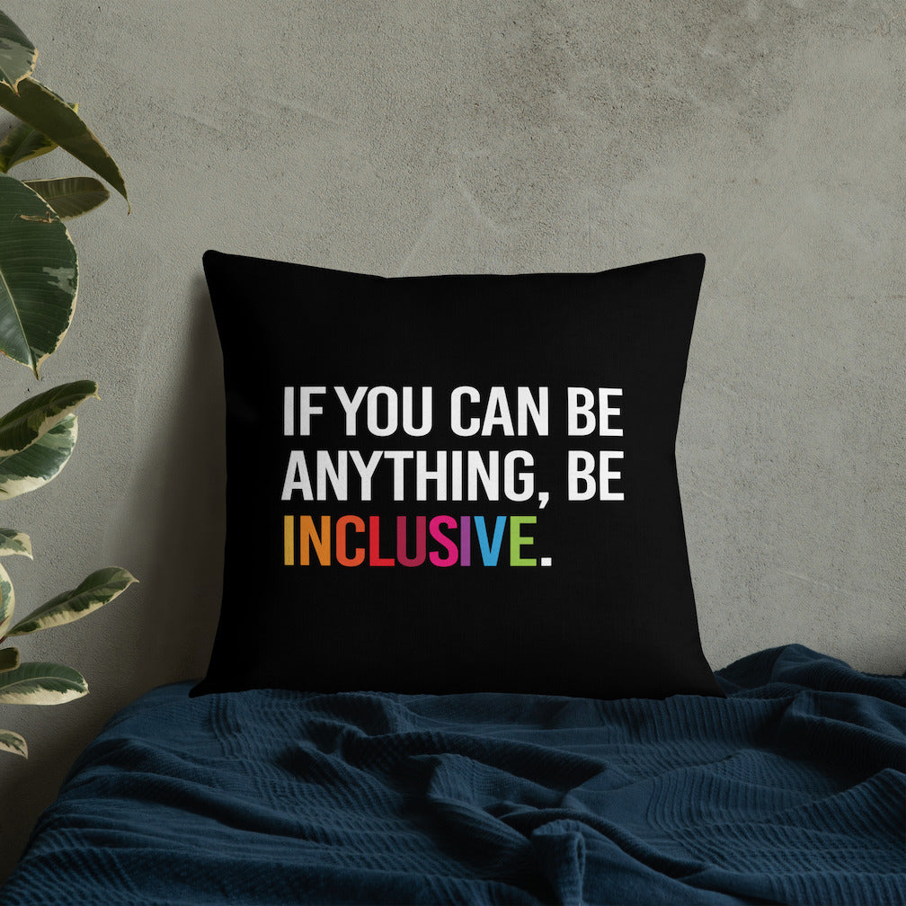 This is an image of a black premium Be Inclusive throw cushion. In the middle of the square throw cushion, the following phrase is printed in white upper case letters, "IF YOU CAN BE ANYTHING, BE INCLUSIVE." The word INCLUSIVE is in rainbow-like colors. 