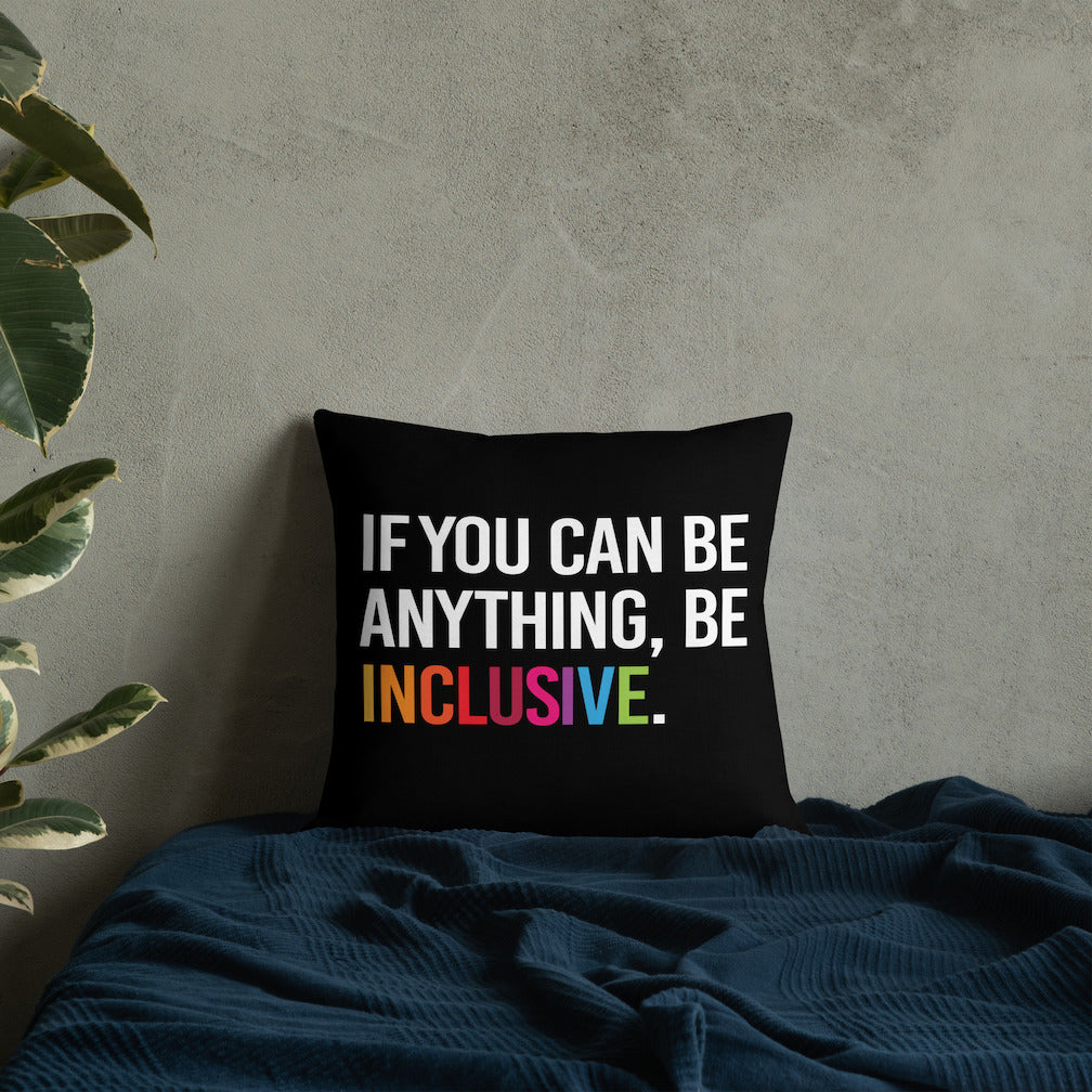 This is an image of a black premium Be Inclusive throw cushion. In the middle of the square throw cushion, the following phrase is printed in white upper case letters, "IF YOU CAN BE ANYTHING, BE INCLUSIVE." The word INCLUSIVE is in rainbow-like colors. 
