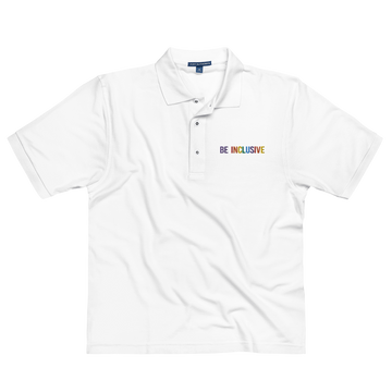 Photo of a premium white Rainbow Be Inclusive Polo Shirt. On the polo's top right panel is the phrase, Be Inclusive, embroidered in red, orange, yellow, green, indigo, and violet. The word 'be' is only in violet.