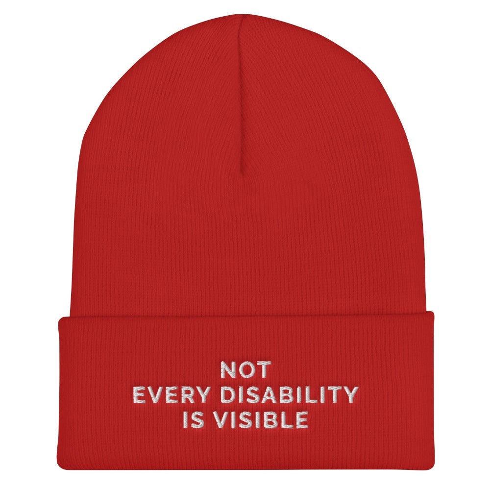 Beanie Inspo - a photo of a red hypoallergenic Not Every Disability Is Visible Beanie lying flat against a plain background. On the cuff of the beanie the phrase, 'Not Every Disability Is Visible,' is embroidered on it over three lines in white upper case letters. 