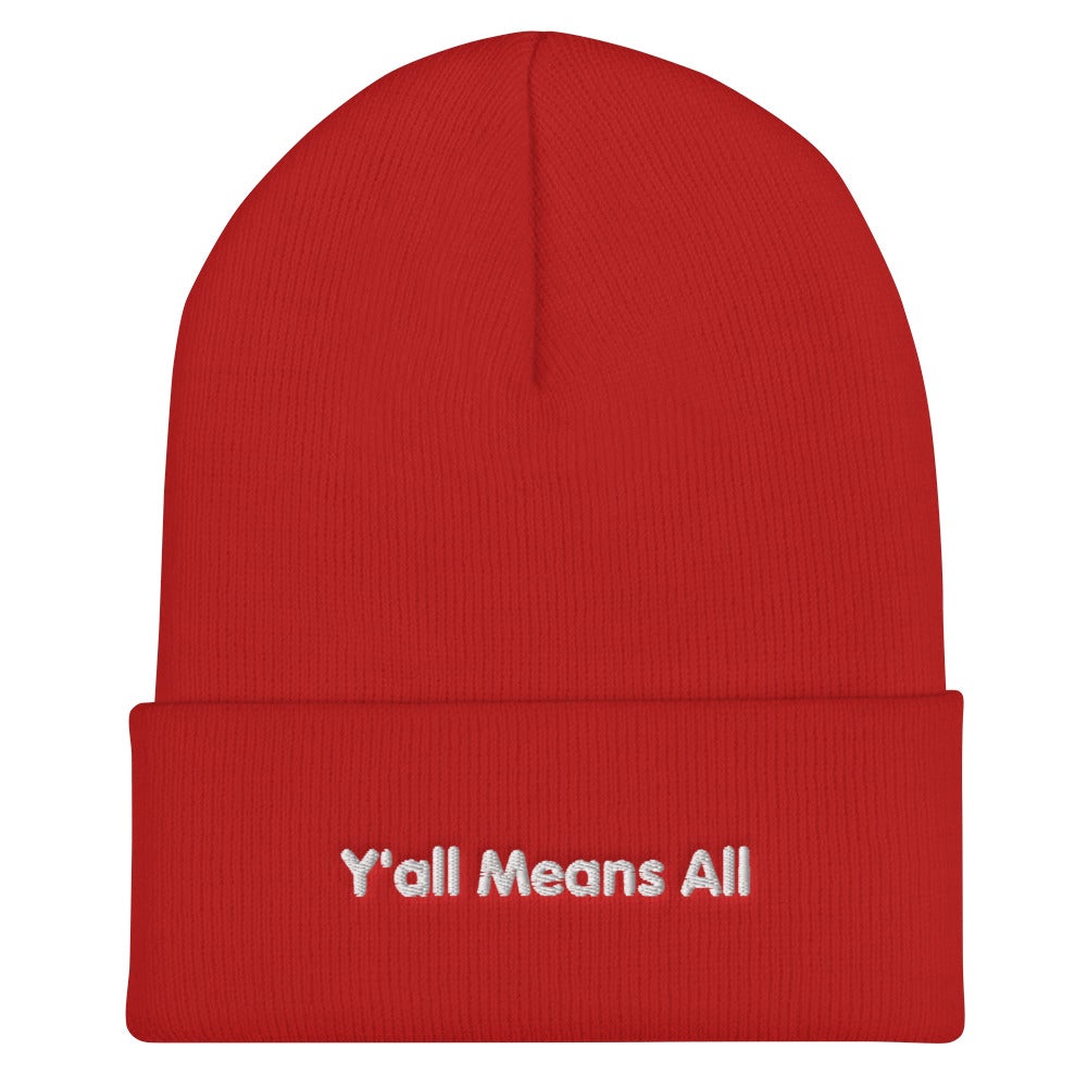 This is a photo of a red-colored Y'all Means All beanie. On the front of the beanie the phrase, 'Y'all Means All,' is embroidered on it in white title case letters. 