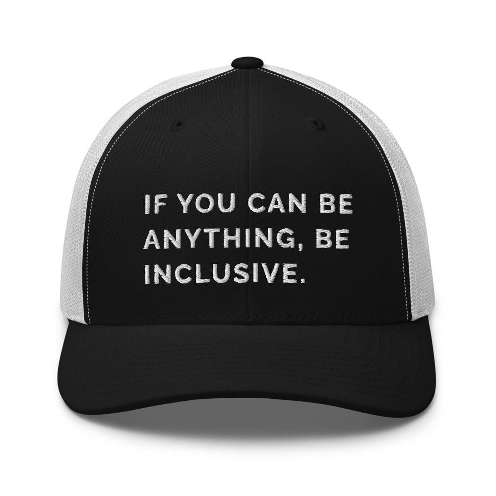 This is a photo of a black and white Be Anything Be Inclusive Trucker Cap. In the middle of the cap's black front panel is the phrase, embroidered in white upper case letters, "If you can be anything, be inclusive." 