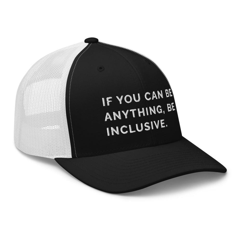 This is a photo of a black and white Be Anything Be Inclusive Trucker Cap. In the middle of the cap's black front panel is the phrase, embroidered in white upper case letters, "If you can be anything, be inclusive." 