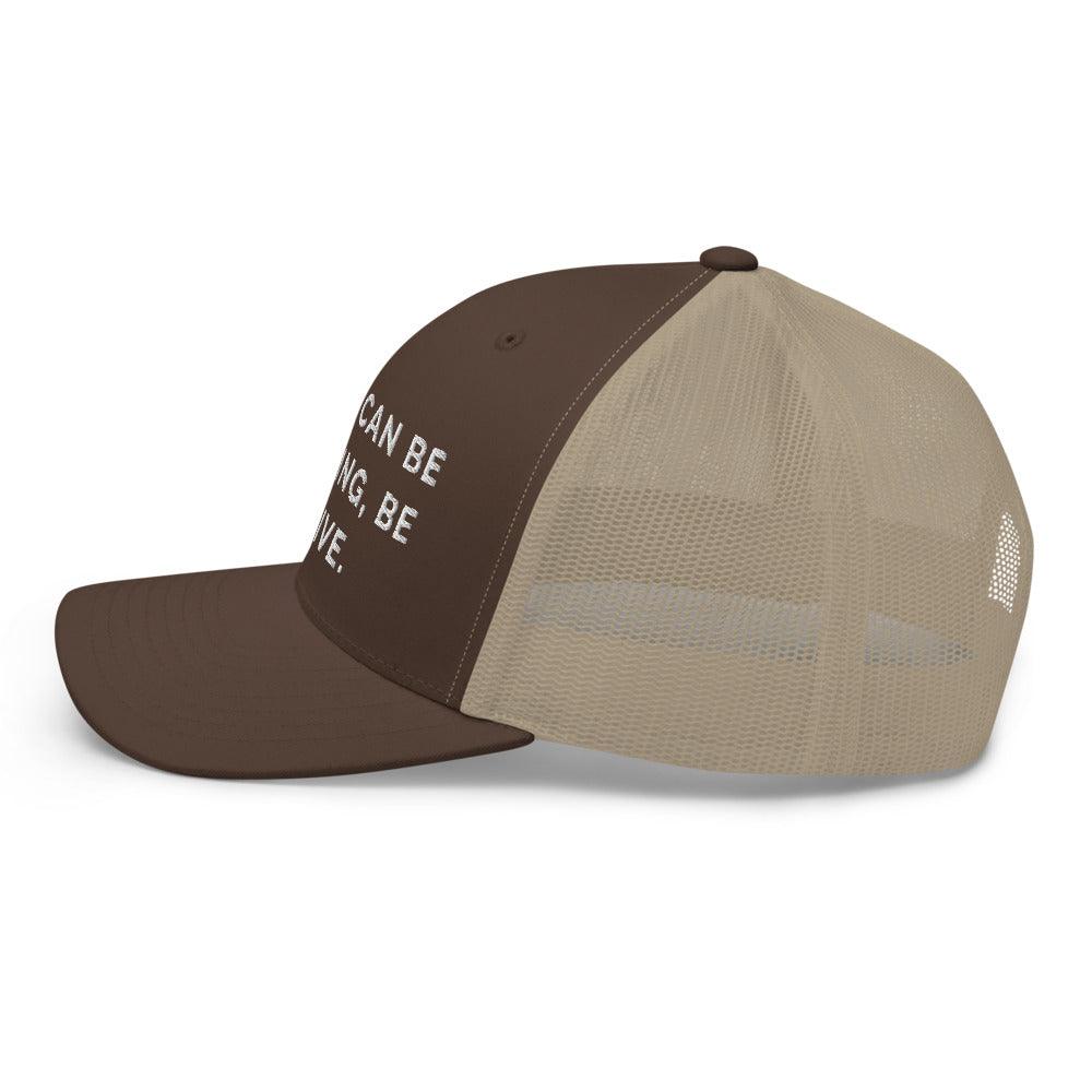 This is a side view of the mesh panels of a Be Anything Be Inclusive Trucker Cap. The cap visor is partially visible. 