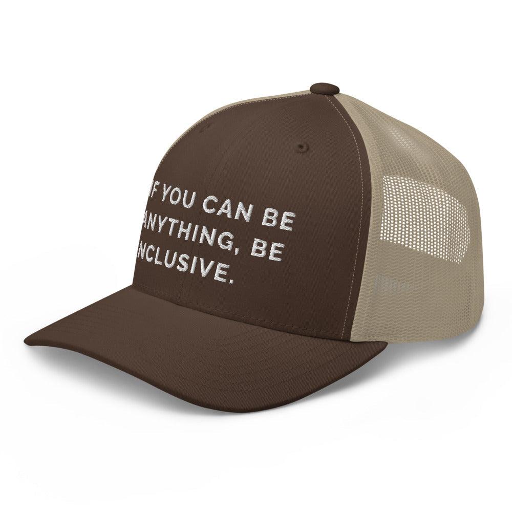 This is a photo of a brown khaki Be Anything Be Inclusive Trucker Cap. In the middle of the cap's brown front panel is the phrase, embroidered in white upper case letters, "If you can be anything, be inclusive." 