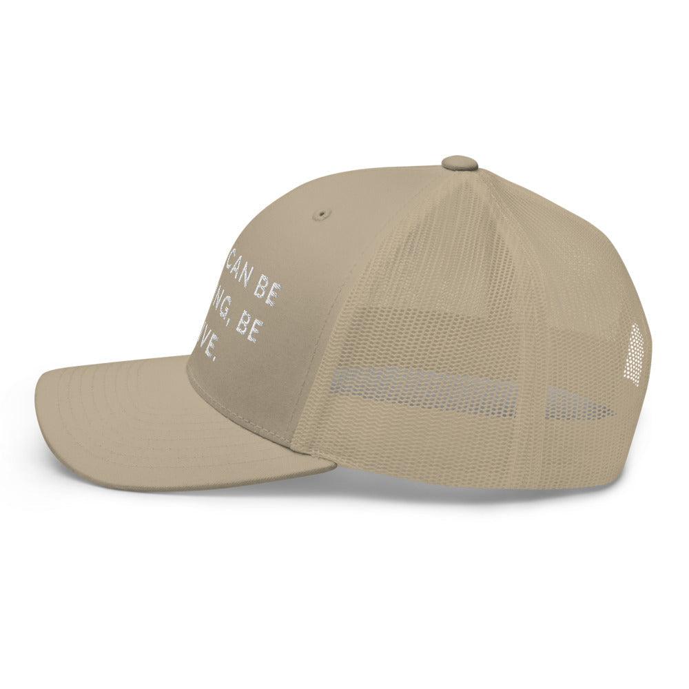 This is a side view of the mesh panels of a Be Anything Be Inclusive Trucker Cap. The cap visor is partially visible. 