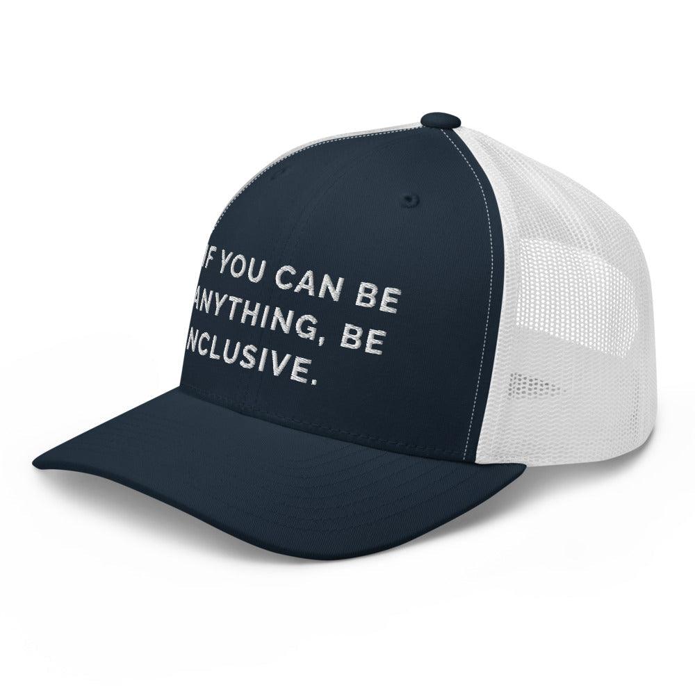 This is a photo of a navy Be Anything Be Inclusive Trucker Cap. In the middle of the cap's front panel is the phrase, embroidered in white upper case letters, "If you can be anything, be inclusive." 