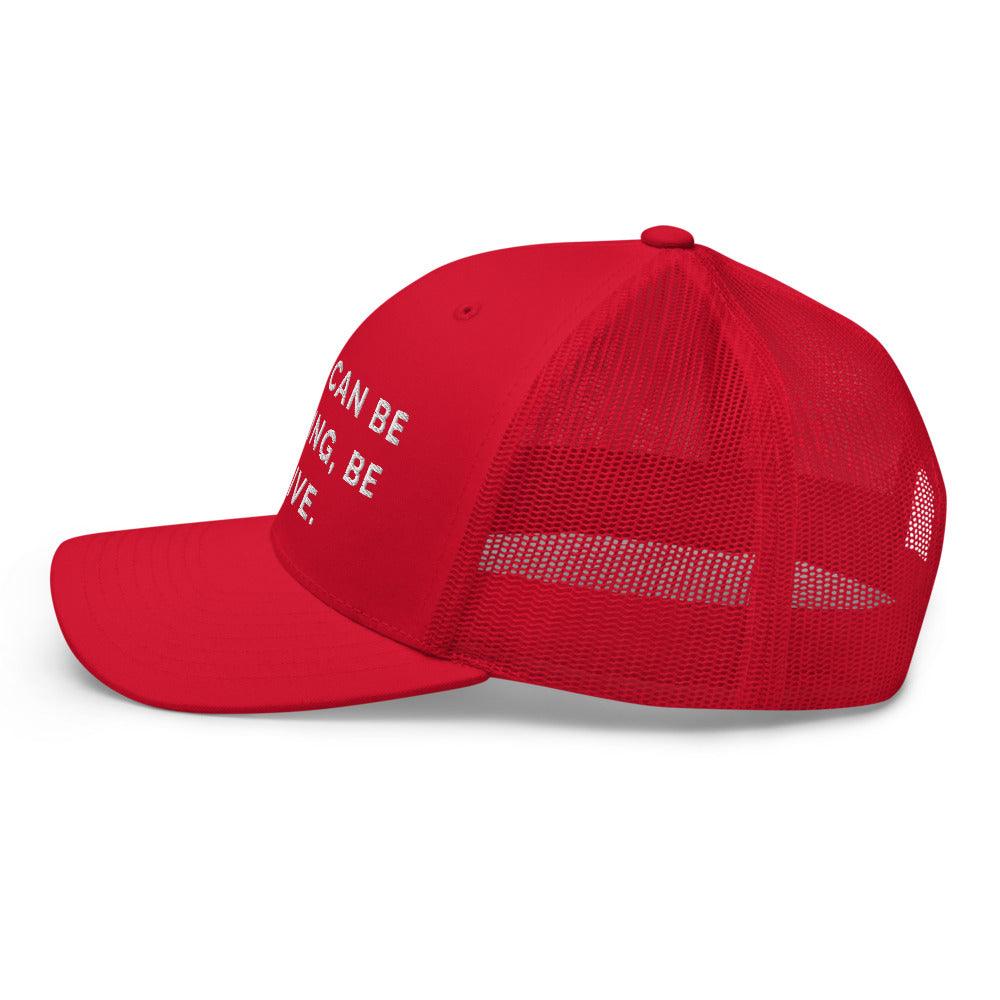 This is a side view of the mesh panels of a Be Anything Be Inclusive Trucker Cap. The cap visor is partially visible. 
