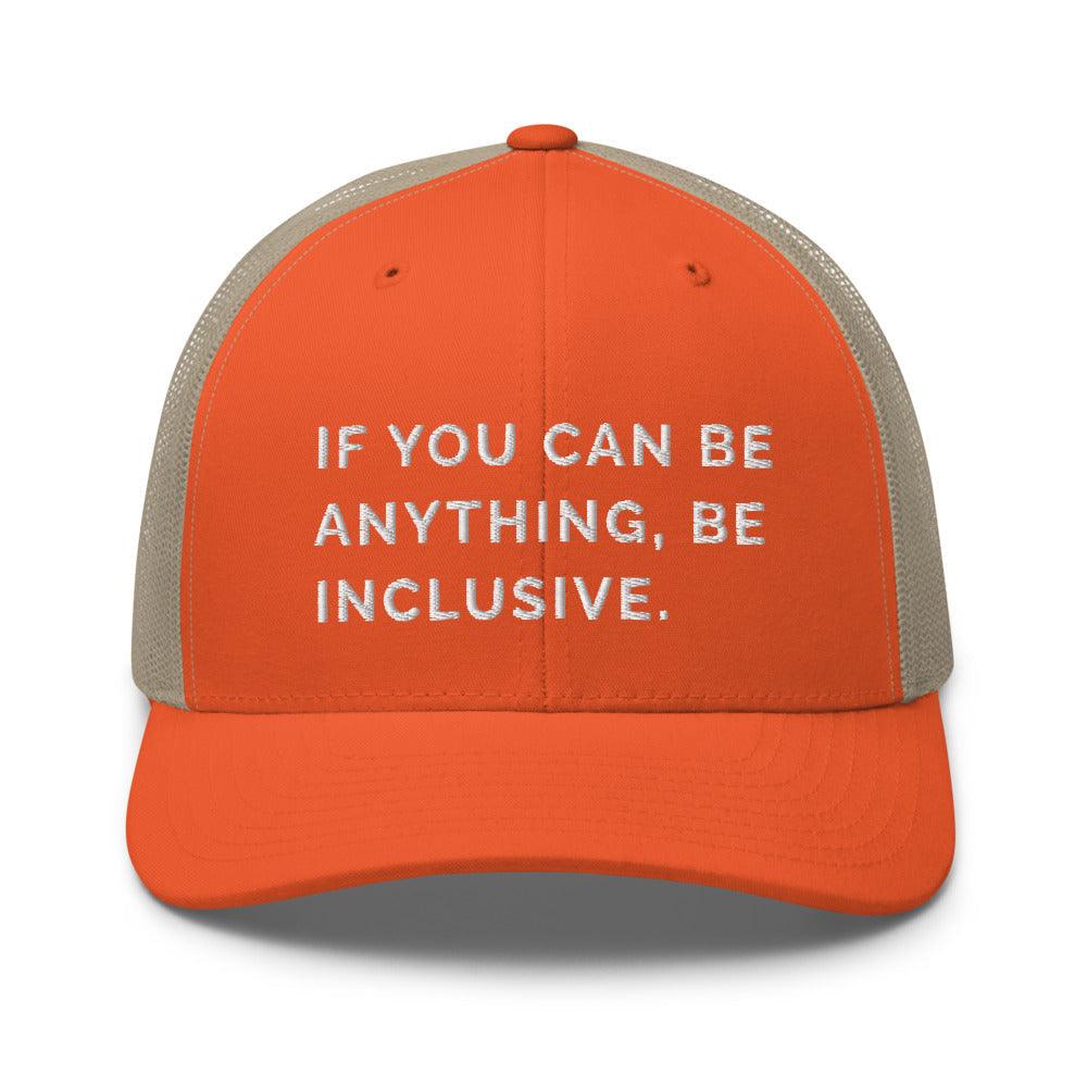 This is a photo of a rustic orange khaki Be Anything Be Inclusive Trucker Cap. In the middle of the cap's orange front panel is the phrase, embroidered in white upper case letters, "If you can be anything, be inclusive." 