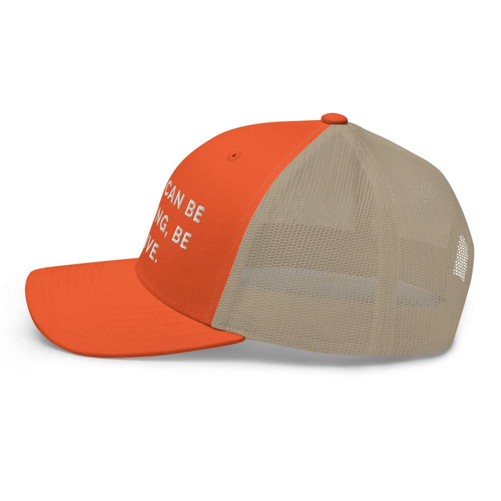 This is a side view of the mesh panels of a Be Anything Be Inclusive Trucker Cap. The cap visor is partially visible. 