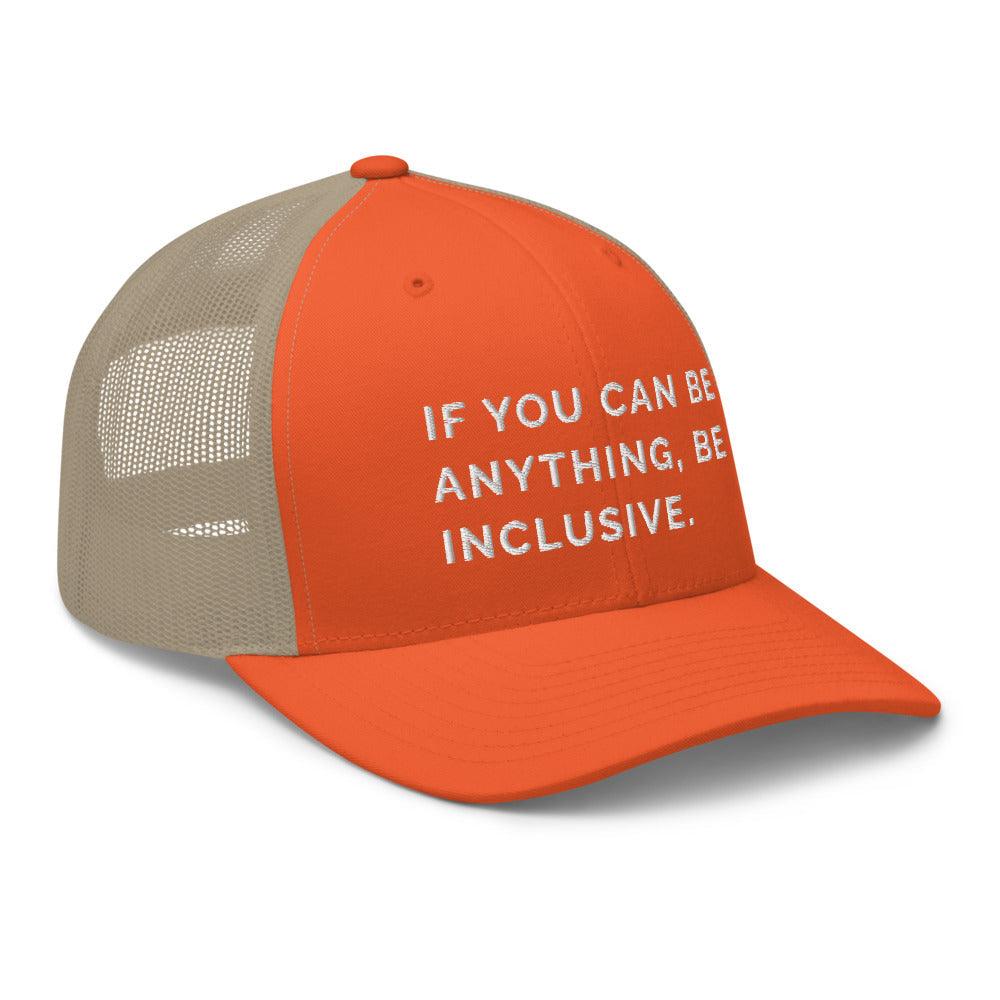 This is a photo of a rustic orange khaki Be Anything Be Inclusive Trucker Cap. In the middle of the cap's orange front panel is the phrase, embroidered in white upper case letters, "If you can be anything, be inclusive." 