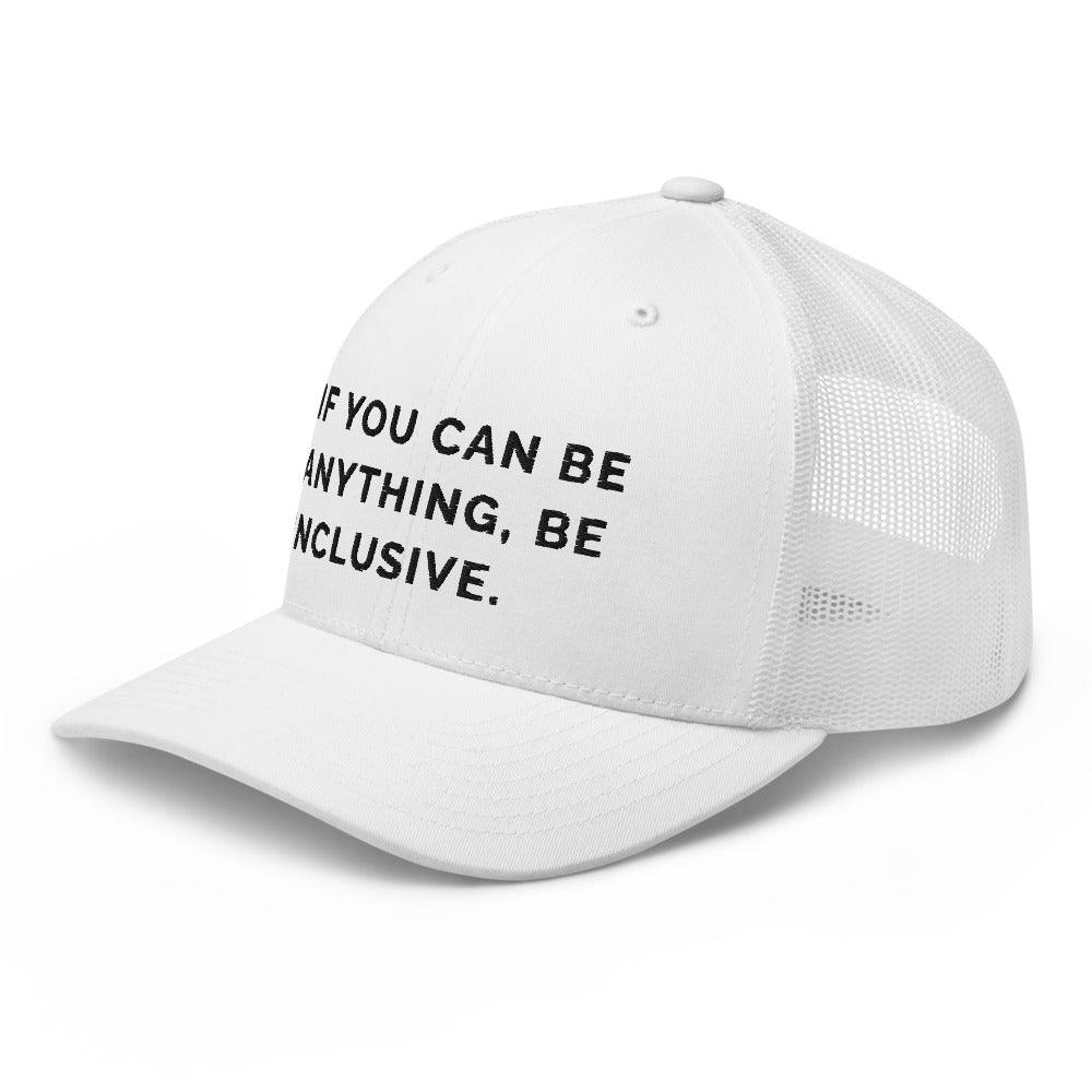 This is a photo of a white Be Anything Be Inclusive Trucker Cap. In the middle of the cap's front panel is the phrase, embroidered in black upper case letters, "If you can be anything, be inclusive." 