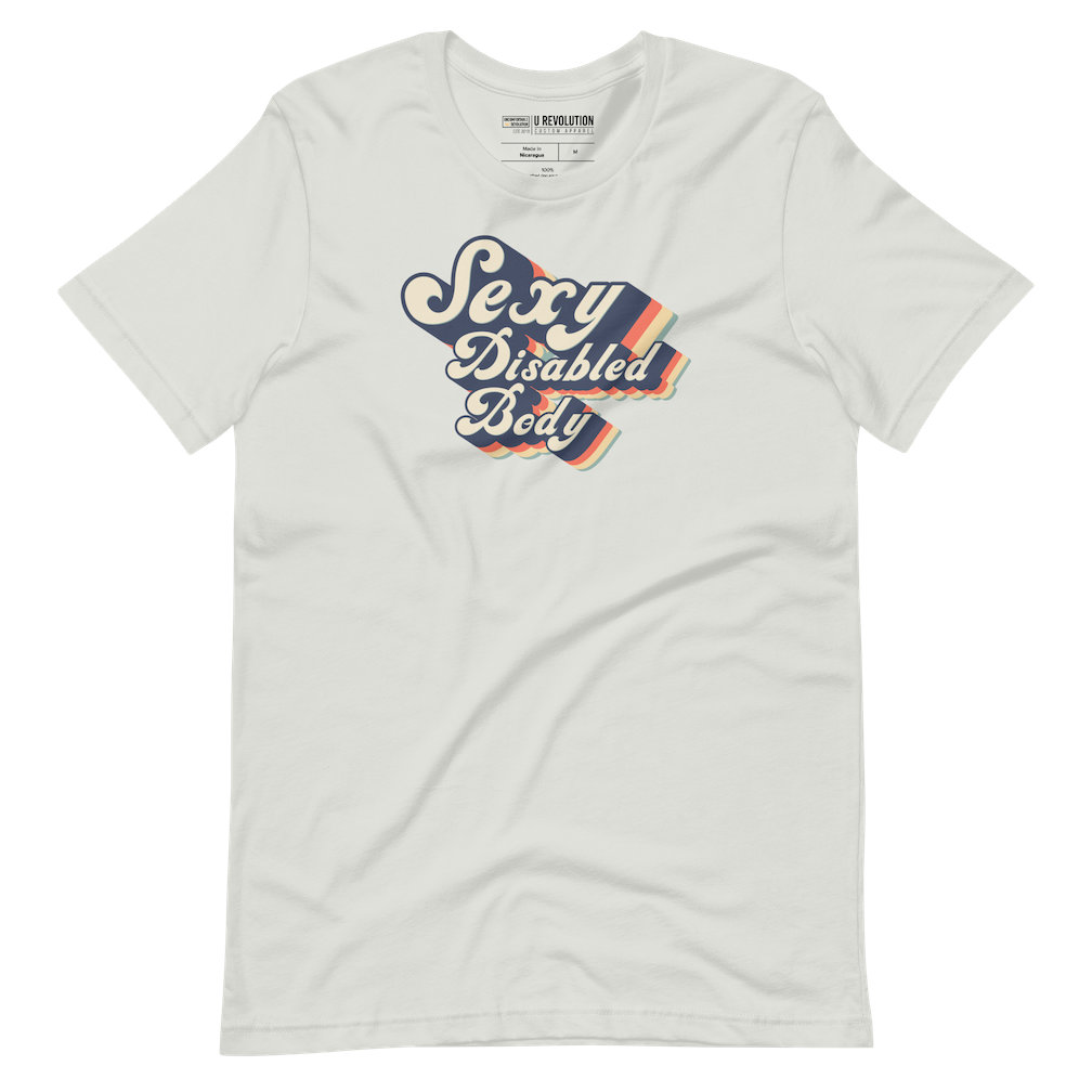 A silver sexy and disabled shirt with the phrase "Sexy Disabled Body" printed on it. The phrase, Sexy Disabled Body, is retro folkloric font.