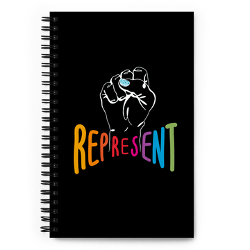 This is a photo of spiral black Represent notebook. In the center of the notebook is a white drawing of a raised clenched fist, with the handwritten word "represent," written in upper case rainbow colors beneath the fist.