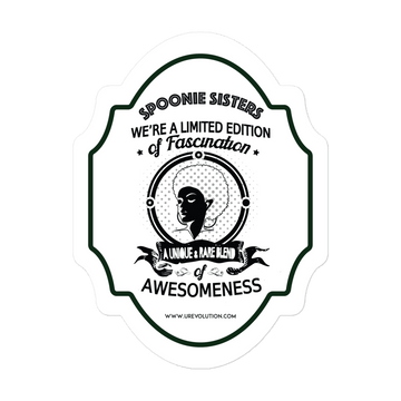 A photo of a spoonie sister sticker. The sticker has black writing on a white background. 1st line: "SPOONIE SISTERS." 2nd line "WE'RE A LIMITED EDITION." 3rd line "of Fascination." In the middle of the sticker is a roundel with a spoon sister with an afro. On the 5th line, on a banner under the roundel, "A UNIQUE & RARE BLEND." 6th line "of." 7th line "AWESOMENESS." "www.urevolution.com" is printed in small font at the bottom of the sticker.