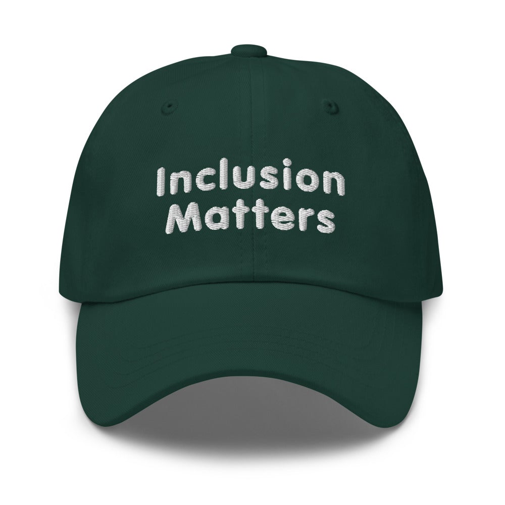 This is a photo of a spruce-colored Inclusion Matters Baseball Cap. On the front of the baseball cap above the visor are two words, 'Inclusion Matters.' printed in white sentence case letters over two lines.