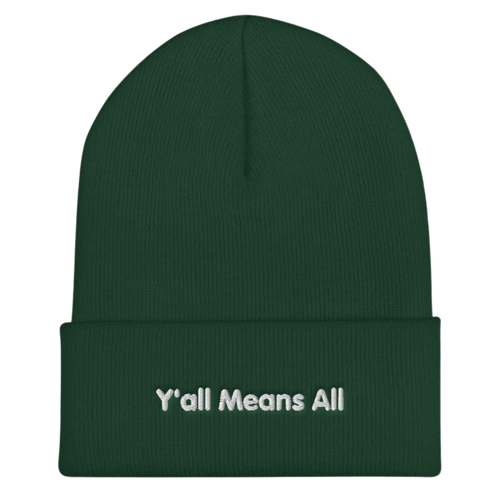 This is a photo of a spruce-colored Y'all Means All beanie. On the front of the beanie the phrase, 'Y'all Means All,' is embroidered on it in white title case letters. 