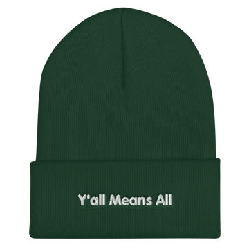 This is a photo of a spruce-colored Y'all Means All beanie. On the front of the beanie the phrase, 'Y'all Means All,' is embroidered on it in white title case letters. 