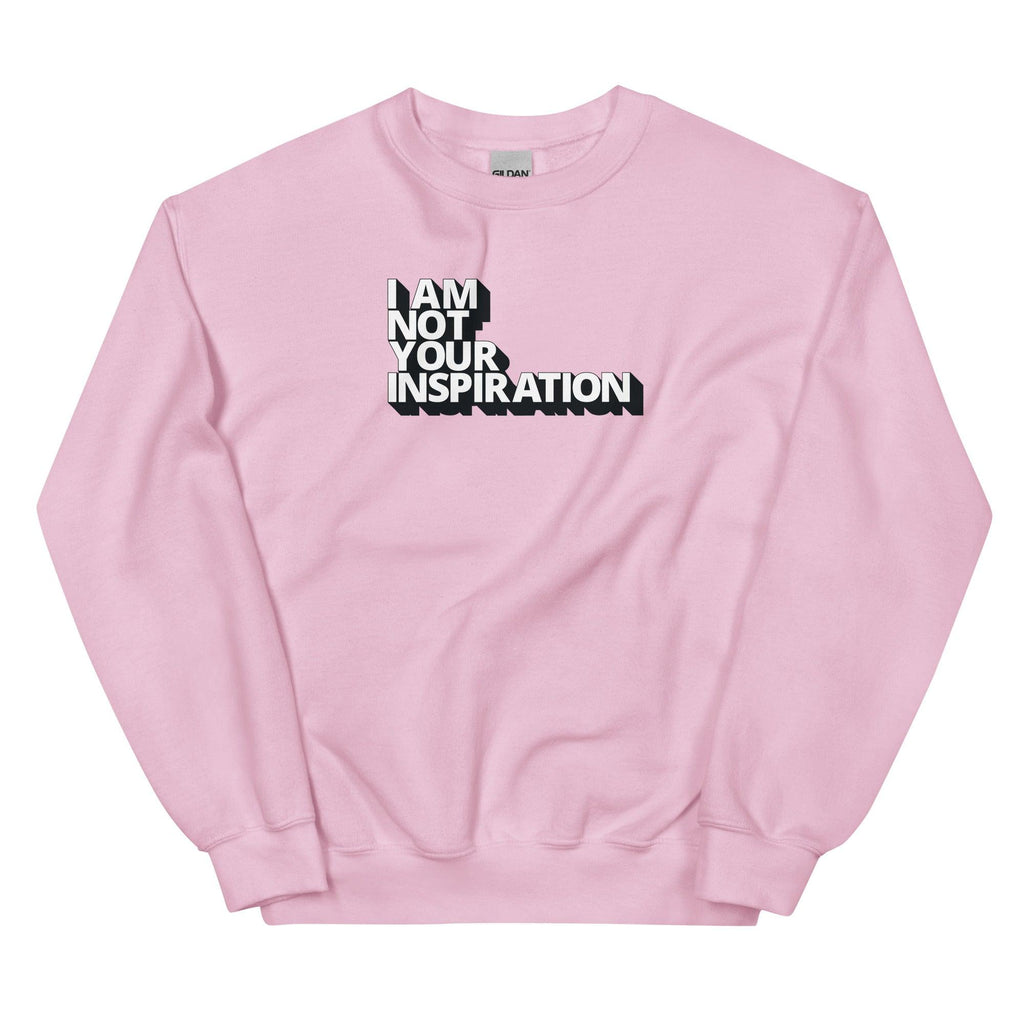 A light pink Not Your Inspiration sweatshirt. On the top third of the inspiration shirt is the phrase, "I am not your inspiration," printed over four lines in white upper case letters with a black retro shadow.