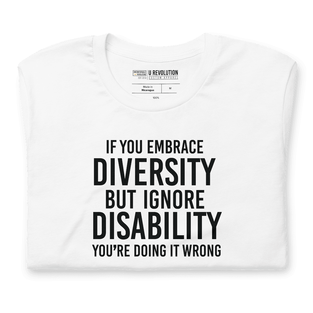 An image of a white Embrace Diversity T-Shirt. The t-shirt features the phrase, printed in white upper case letters, "If you embrace diversity but ignore disability, you're doing it wrong."