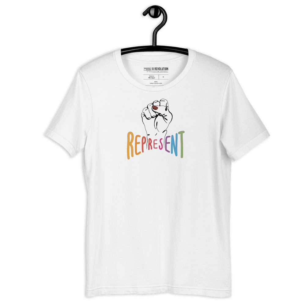 White represent t-shirt. In the middle of the represent shirt is a black line drawing of a raised clenched fist, with the handwritten word "represent," written in upper case rainbow colors. The t-shirt is on a black hanger.