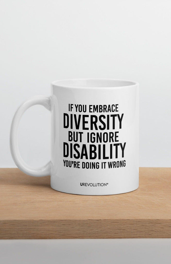 Photo of a white embrace diversity mug. The embrace diversity mug has a phrase printed in black in upper case letters: "If you embrace diversity but ignore disability, you're doing it wrong." The phrase takes up ¾ of the front side of the mug.