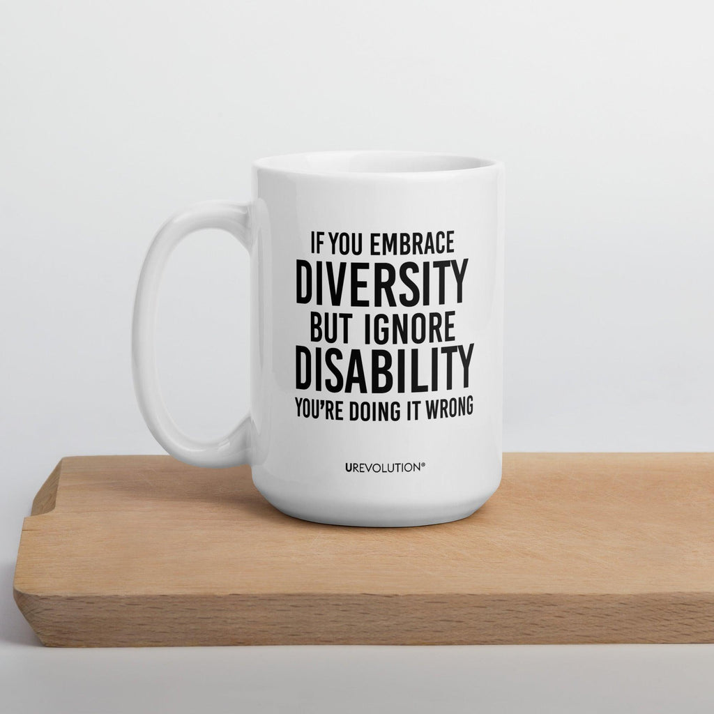 Photo of a white embrace diversity mug. The embrace diversity mug has a phrase printed in black in upper case letters: "If you embrace diversity but ignore disability, you're doing it wrong." The phrase takes up ¾ of the front side of the mug.