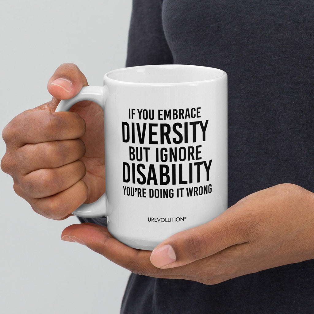 Photo of a white embrace diversity mug. The embrace diversity mug has a phrase printed in black in upper case letters: "If you embrace diversity but ignore disability, you're doing it wrong." The phrase takes up ¾ of the front side of the mug.