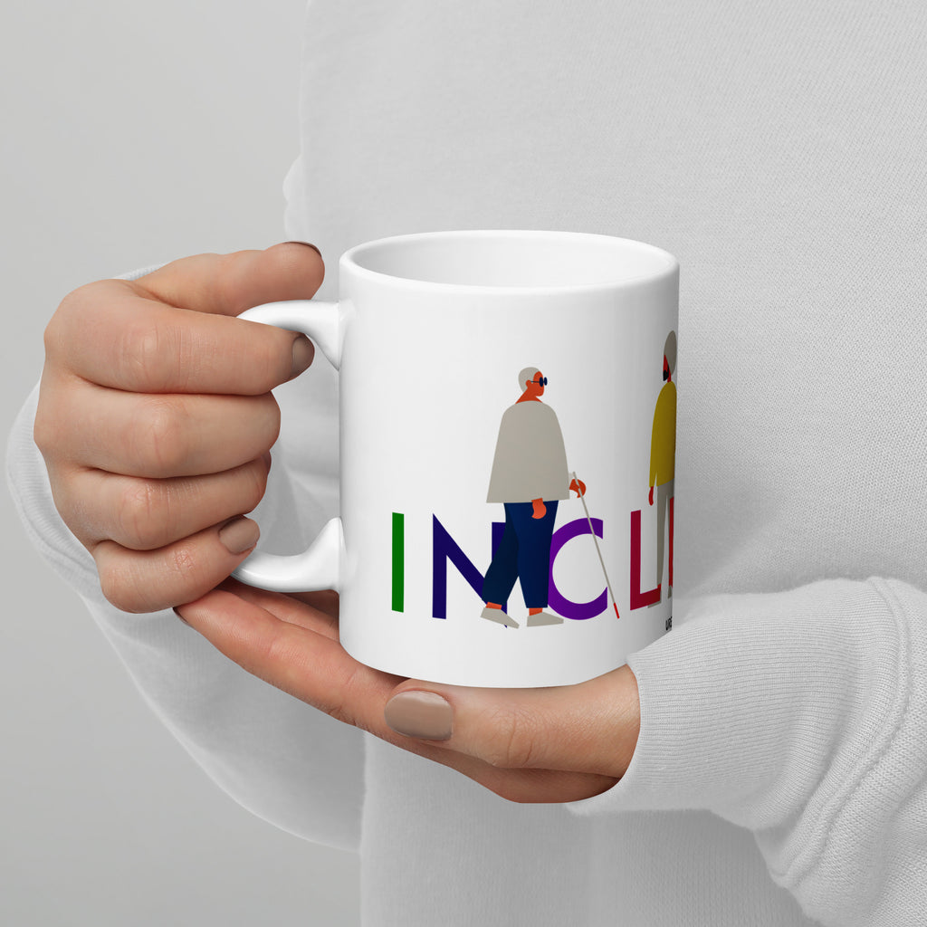 This is a photo of a white inclusion mug with URevolution's Inclusion icon on the side. The word INCLUSION is written in all caps in rainbow colors. Among the letters are four characters: one plus-sized person with glasses and a cane, one person with one arm wearing a turban, one person with long hair and a prosthetic leg, and one person with an afro, seated in a wheelchair.