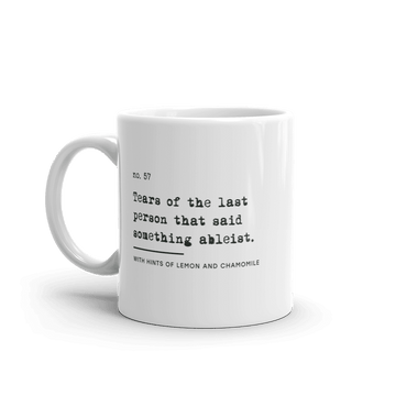White ceramic mug with black text reading: “no. 57. Tears of the last person that said something ableist. With hints of lemon and chamomile.”