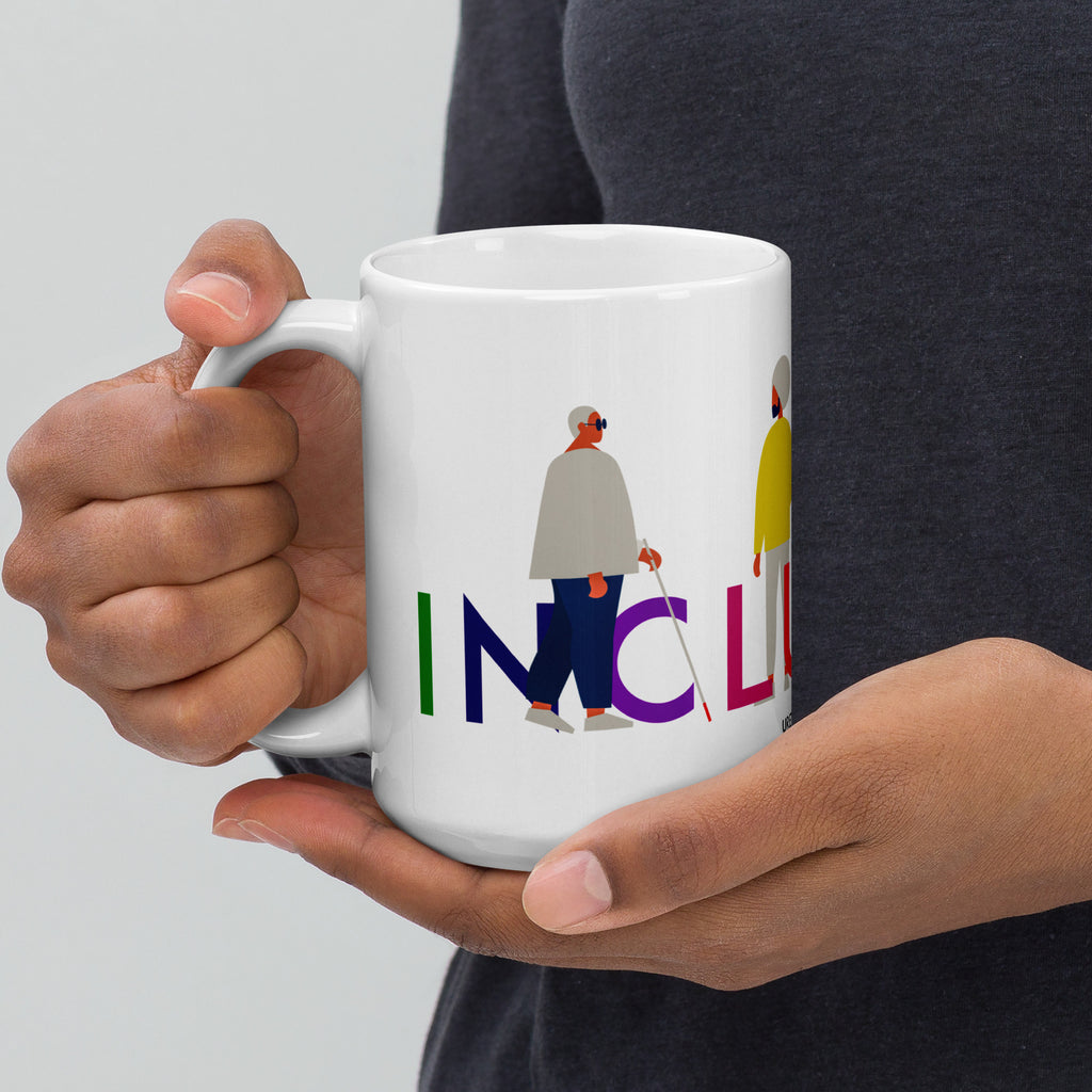 This is a photo of a white inclusion mug with URevolution's Inclusion icon on the side. The word INCLUSION is written in all caps in rainbow colors. Among the letters are four characters: one plus-sized person with glasses and a cane, one person with one arm wearing a turban, one person with long hair and a prosthetic leg, and one person with an afro, seated in a wheelchair.