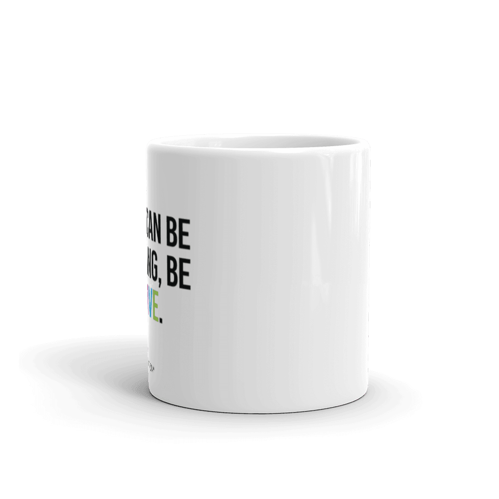 11oz Be Inclusive mug. On the right-hand side of the mug, facing the screen, is the phrase, 'If you can be anything, be inclusive,' printed in large black upper case letters. The word 'inclusive' is in the color of the rainbow. At the bottom edge of the inclusive mug is the word, URevolution, printed in small black upper case letters. 