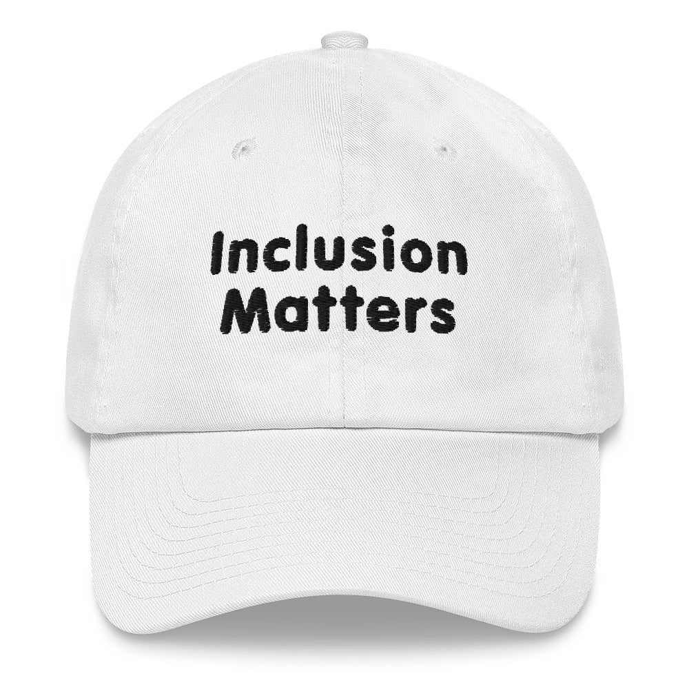 This is a photo of a white Inclusion Matters Baseball Cap. On the front of the baseball cap above the visor are two words, 'Inclusion Matters.' printed in black sentence case letters over two lines.