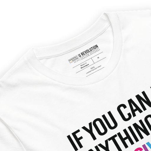 This is a photo of a white rainbow classic Be Inclusive tee. On the front of the inclusive t-shirt is the phrase: "If you can be anything, be inclusive," in black upper case letters. All the text is in black, except "Inclusive," which is in rainbow colors.