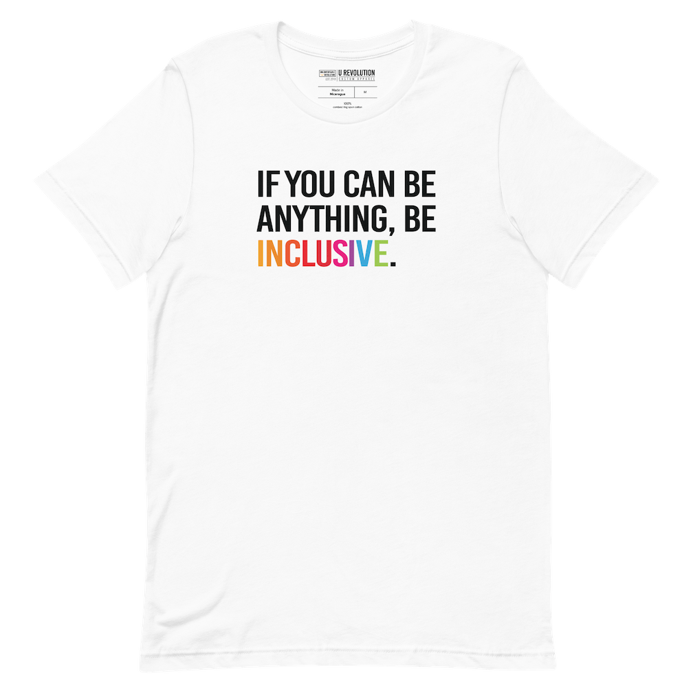 This is a photo of a white rainbow classic Be Inclusive tee. On the front of the inclusive t-shirt is the phrase: "If you can be anything, be inclusive," in black upper case letters. All the text is in black, except "Inclusive," which is in rainbow colors.